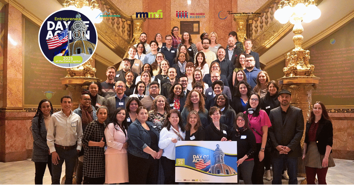 A large group of diverse entrepreneurs pose on a grand staircase with ornate golden railings, holding a banner for "2025 Day of Action." The setting appears to be an elegant building with decorative columns and lighting.