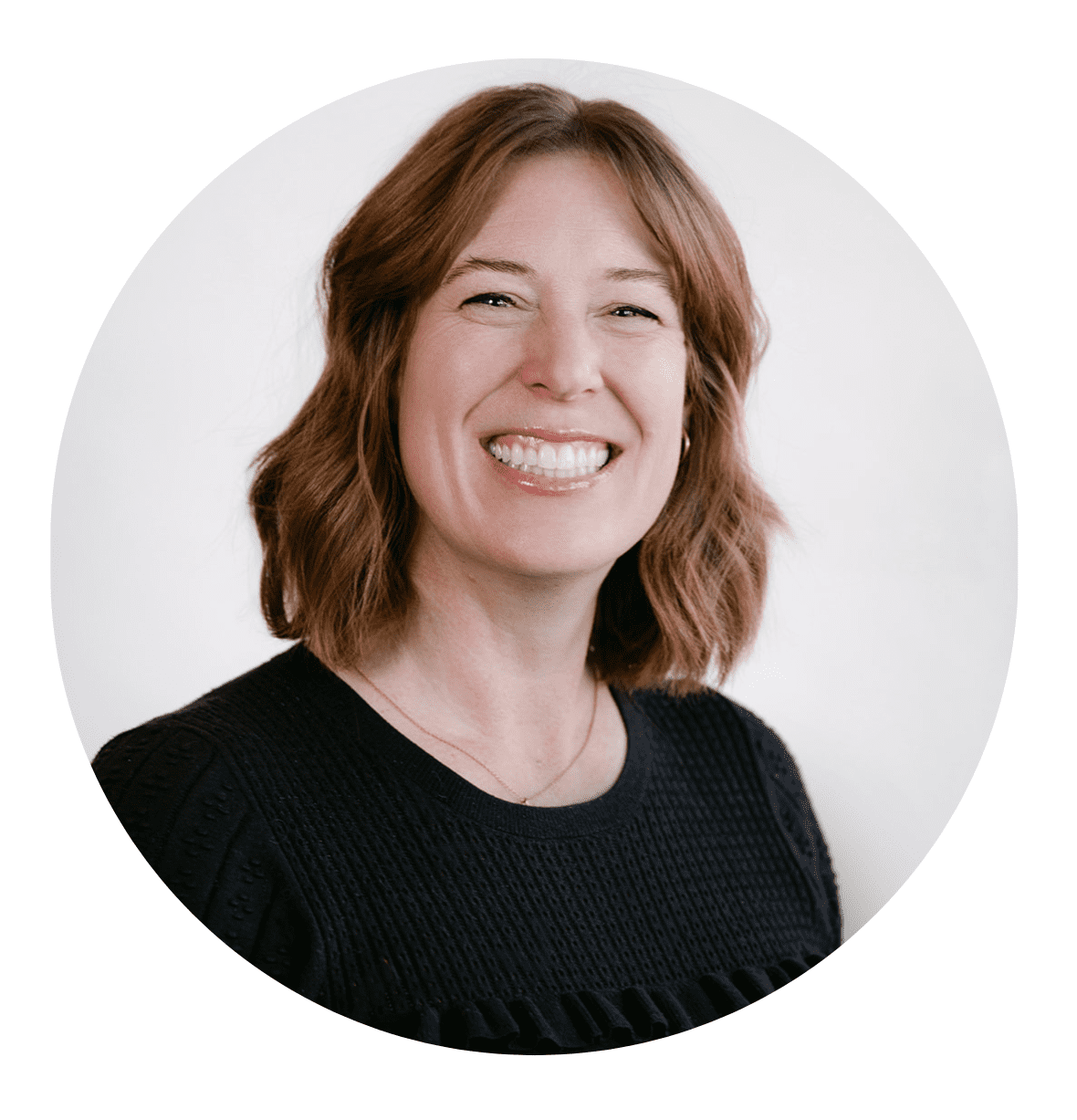 A woman with shoulder-length brown hair smiles broadly. She is wearing a black textured top and is posed in front of a plain white background, cropped in a circular frame—perfect for an About RMMFI profile or team page.