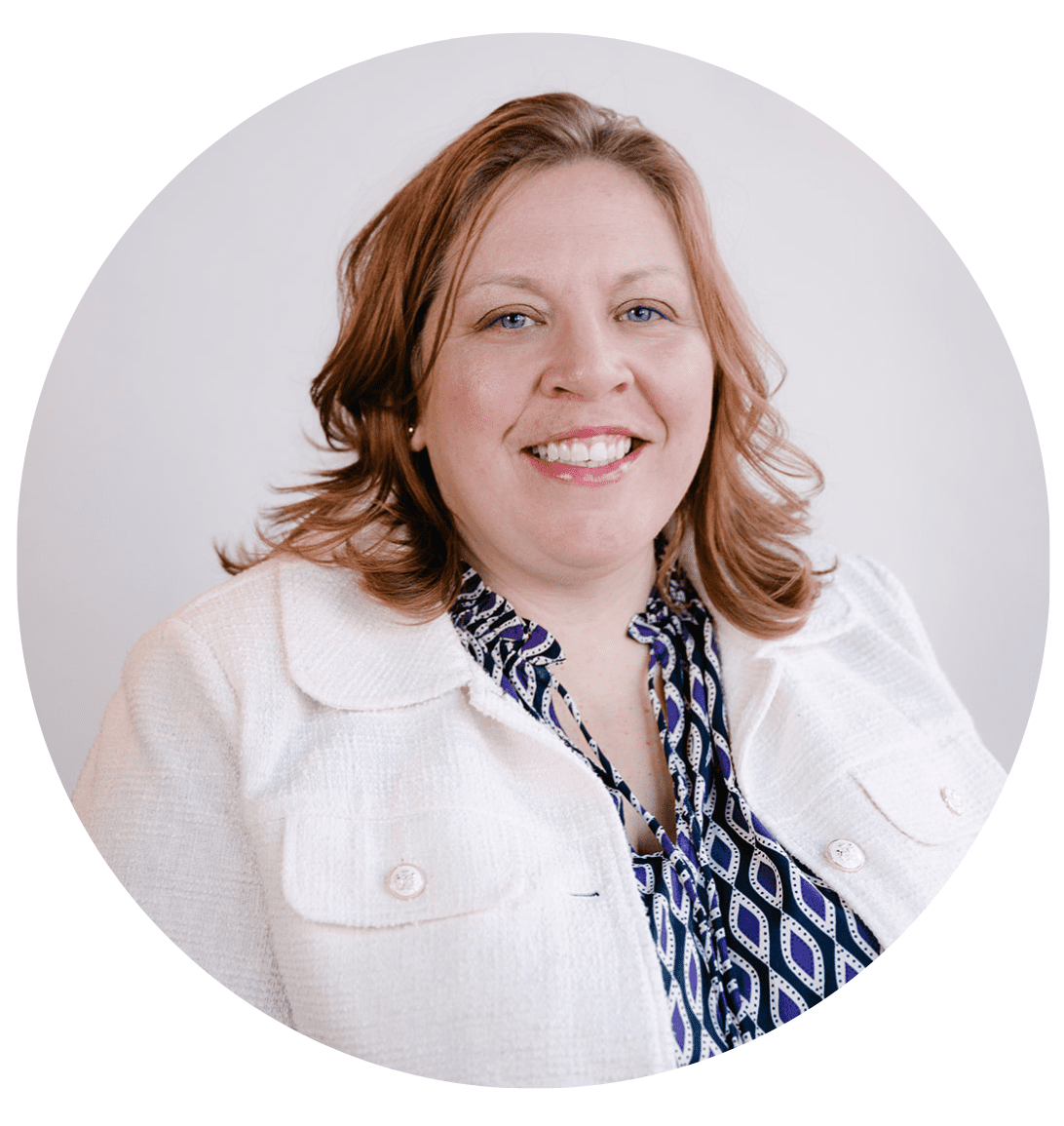 A woman with shoulder-length light brown hair smiles at the camera. She is wearing a white jacket over a patterned blouse, set against a plain white background within a circular frame, embodying the welcoming spirit of About RMMFI.