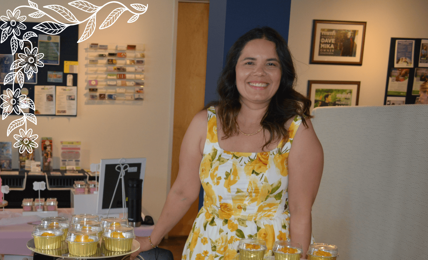 A woman in a yellow floral dress stands behind a table displaying stacked desserts in clear cups at a market or event, possibly as part of a Colorado Business Launch Boot Camp. Decorative white floral graphics and the text “Sweeto & Treato” are on the image, adding to the festive atmosphere.
